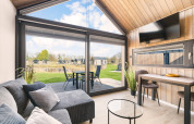 Moderna cabaña Reestdal en el camping Si-Es-An en Países Bajos con ventanales y vistas a la naturaleza.