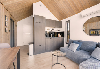 Moderno loft 'Reestdal' al campeggio Si-Es-An nei Paesi Bassi, con dettagli in legno e cucina compatta.