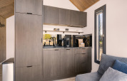 Modern kitchenette with gray cabinets and appliances in «Reestdal» loft at Campsite Si-Es-An, Netherlands.