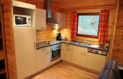 Moderne Küche im Holzchalet ‘De Boshut’ in Belgien mit Geräten, Fenster und Holzverkleidung.