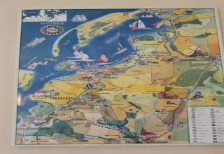 Kleurrijke kaartposter aan de muur bij Am Strand lodge in Duitsland, toont de Oostzeekustregio.