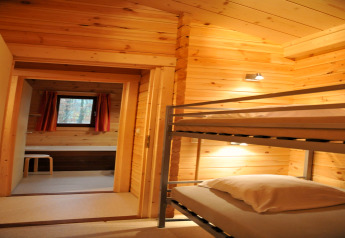 Gemütliches Schlafzimmer mit Etagenbett und Holzverkleidung in der Chalet “De Boshut” in Belgien.