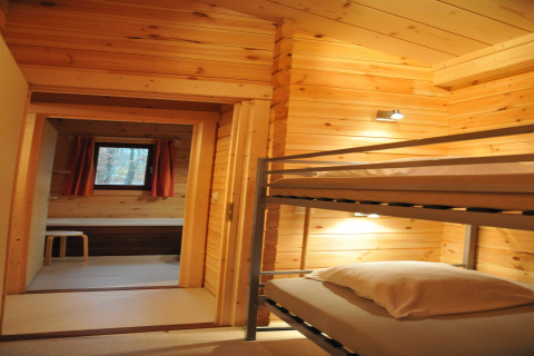 Chambre chaleureuse avec lits superposés et murs en bois dans le chalet “De Boshut” en Belgique.
