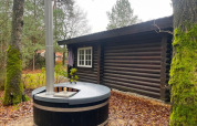 Foto exterior de una cabaña de madera y jacuzzi en Romantic Lodge en Outdoors Holten, Países Bajos.