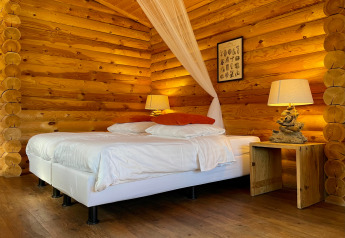 Chambre de lodge romantique avec lit double et éclairage chaleureux à Outdoors Holten, Pays-Bas.