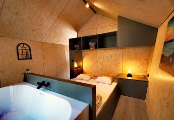 Tiny house moderna Diamond Suite con vasca da bagno e luce accogliente da Outdoors Holten nei Paesi Bassi.