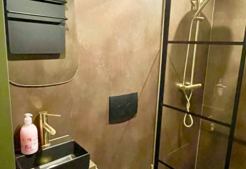 Bagno moderno della Diamond Suite con doccia e WC nero presso Outdoors Holten, Paesi Bassi.
