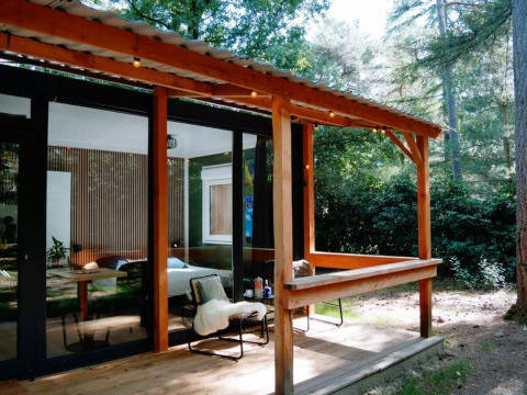 Gemütliche Holzhütte mit überdachter Terrasse im Wald bei Forest Cabin, Outdoors Holten, Niederlande.