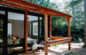 Houten hut met overdekte veranda in het bos bij Forest Cabin, Outdoors Holten, Nederland.