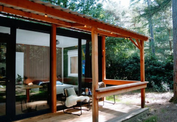 Cabane en bois avec terrasse couverte en pleine forêt à Forest Cabin, Outdoors Holten, Pays-Bas.