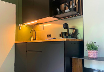 Moderne tekøkken i sorte toner med træbordplade i Forest Cabin hos Outdoors Holten, Holland.