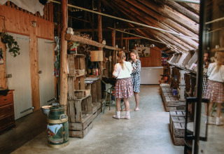 Niñas juegan dentro de un granero rústico en BoerenBed De Kalverweide, parque vacacional en Overijssel, Países Bajos.