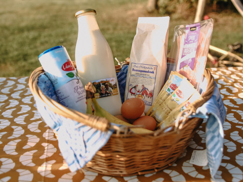 Cesta con leche, harina, huevos y otros ingredientes en BoerenBed De Kalverweide, Overijssel, Países Bajos.