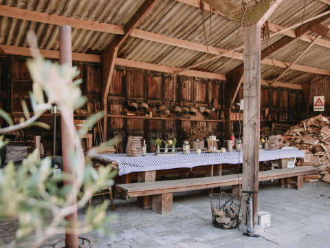 Zona de comedor rústica en establo con bancos de madera y mantel a cuadros en Overijssel, Países Bajos.