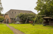 Foto de un patio de recreo y un granero en el parque vacacional BoerenBed Het Boshuis en Gelderland, Países Bajos.