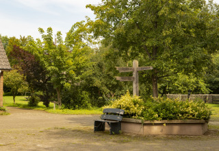 Área tranquila en BoerenBed Het Boshuis, Gelderland, con banco, naturaleza y señales de dirección de madera.