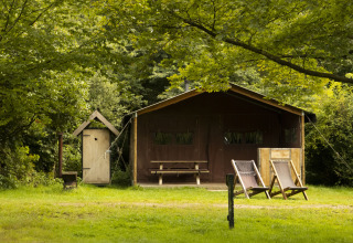 Außenansicht einer Safarizelt-Unterkunft mit Liegestühlen und viel Grün bei BoerenBed Het Boshuis, Gelderland.