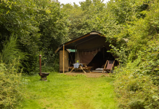 Tente glamping rustique entourée de verdure à BoerenBed Het Boshuis, parc de vacances aux Pays-Bas.