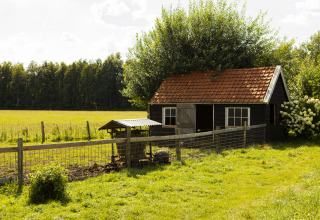 Maison de ferme au toit rouge et enclos à BoerenBed De Lange Weide, parc de vacances à Drenthe, Pays-Bas.