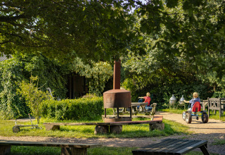 Kinder spielen im Grünen im Ferienpark BoerenBed De Lange Weide in Drenthe, Niederlande, an einem Sommertag.
