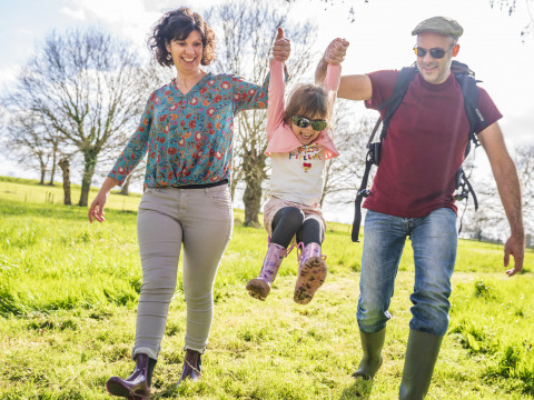 Una famiglia felice passeggia tra l’erba al BoerenBed L’Étable des Mauges en Anjou in Pays de la Loire, Francia.
