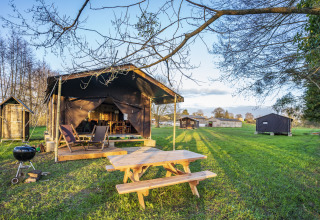Tienda de glamping con mesa de picnic y barbacoa en BoerenBed L'Étable des Mauges en Anjou, Países del Loira, Francia.