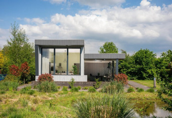 Moderne Boslodge Plus met grote ramen en terras, omgeven door natuur bij 't Schuttenbelt in Nederland.