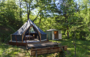 Tenda safari Inuit Forest Tent al Campeggio Des Randonneurs in Francia, immersa nel bosco e casetta.