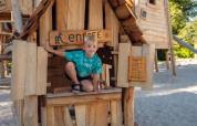 Niño jugando en una casita de madera en el parque infantil del parque vacacional Molenvelden, Brabante Septentrional, Países Bajos.