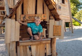 Bambino che gioca in una casetta di legno nell’area giochi del parco vacanze Molenvelden, Brabante Settentrionale, Paesi Bassi.