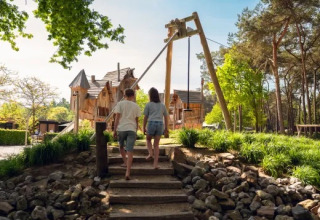 Zwei Kinder gehen eine Treppe entlang im Ferienpark Molenvelden in Nordbrabant, Niederlande, im Grünen.