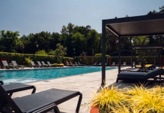 Udendørs swimmingpool med solvogne og pavilloner i ferieparken Molenvelden, Nord-Brabant, Holland.
