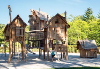 Trælegeplads med broer og hytter i solskin, et af højdepunkterne i Holiday park Molenvelden, Holland.