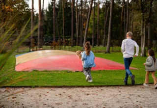 Børn løber mod en farverig hoppepude i ferieparken Molenvelden i North-Brabant, Holland.