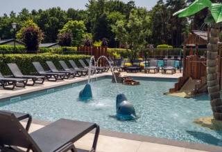 Area piscina all'aperto con lettini, giochi d'acqua e parco giochi presso Holiday Park Molenvelden, Noord-Brabant.