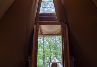 Uitzicht vanuit een moderne tipi op Campsite Des Randonneurs in Frankrijk, met picknicktafel buiten.
