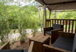 View from the terrace of a Safari Lodge tent with wooden furniture at Campsite Des Randonneurs in France.