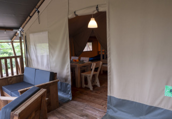 Interior of a Safari Lodge tent with wooden furniture on Campsite Des Randonneurs in France.