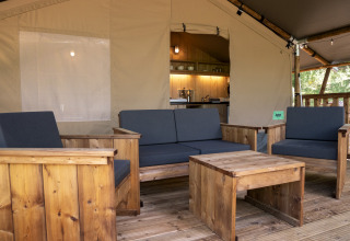 Houten meubels en gezellige zithoek in Safari Lodge LUXE tent op Camping Des Randonneurs, Frankrijk.