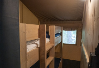 Interieur van de Safari Lodge LUXE tent op Camping Des Randonneurs in Frankrijk, met houten stapelbedden.