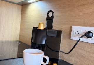 Koffiemachine met capsules en witte tas op Mobi Lodge aanrecht, Arden Parks Tulderheyde, België.