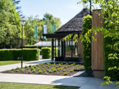 Außenbereich des Holiday Park «Molenvelden» in Nordbrabant mit moderner Hütte und gepflegtem Garten.