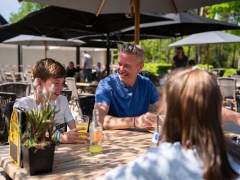 Famiglia che beve insieme all'aperto al parco vacanze Molenvelden, Brabante Settentrionale, Paesi Bassi.