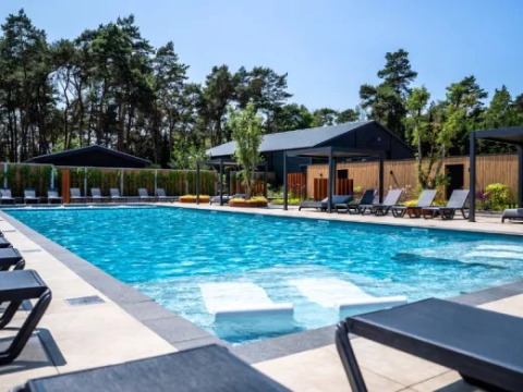 Outdoor swimming pool with lounge chairs and modern amenities at Holiday park Molenvelden, North-Brabant, Netherlands.