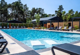 Udendørs swimmingpool med liggestole og moderne faciliteter i ferieparken Molenvelden, North-Brabant, Holland.
