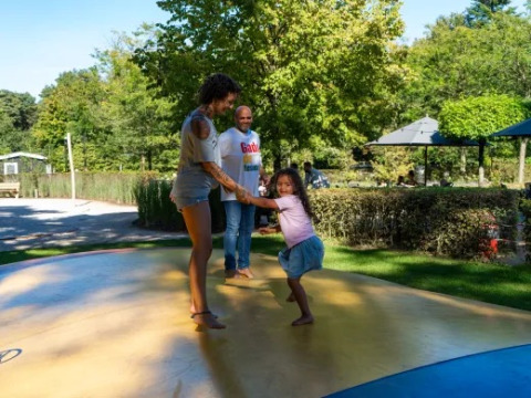 En familie leger på en udendørs oppustelig hoppepude i Holiday park Molenvelden i Nord-Brabant, Holland.