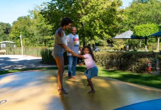 En familie leger på en udendørs oppustelig hoppepude i Holiday park Molenvelden i Nord-Brabant, Holland.