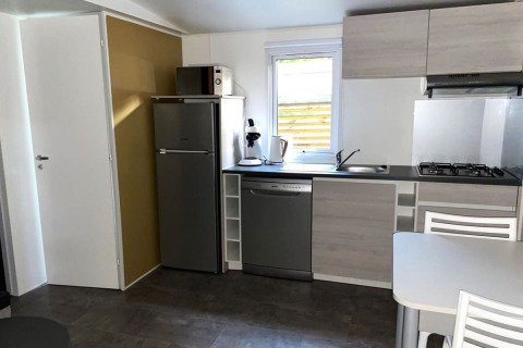 Gezellige keuken in Comfort Mobile Home op Camping Paradis Family des Issoux met koelkast, vaatwasser en kookplaat.