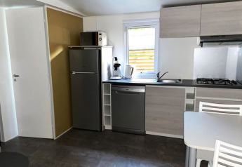 Moderne Küchenzeile mit Kühlschrank, Geschirrspüler, Herd, Mikrowelle und Fenster im Comfort Mobile Home, Frankreich.