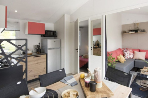 Comfort mobiele woning met drie slaapkamers, moderne keuken, eetruimte en zithoek bij Camping Paradis Family des Issoux.
